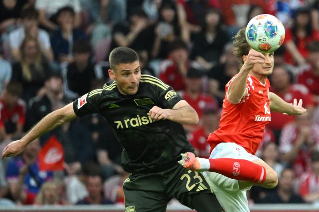 10 May 2026, Rhineland-Palatinate, Mainz: Mainz' Stefan Posch and Union Berlin's Andrej Ilic battle for the ball during the German Bundesliga soccer match between FSV Mainz 05 and 1.FC Union Berlin at Mewa Arena. Photo: Torsten Silz/dpa - IMPORTANT NOTE: In accordance with the regulations of the DFL German Football League and the DFB German Football Association, it is prohibited to utilize or have utilized photographs taken in the stadium and/or of the match in the form of sequential images and/or video-like photo series.