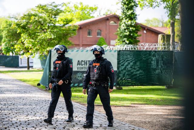 13 May 2026, Lower Saxony, Verden: Armed police are deployed in front of the converted riding facility, which is being used as a temporary courtroom for the Verden district court. In the trial against former RAF terrorist Daniela Klette for aggravated robbery, pleas from the defense are expected. Photo: Sina Schuldt/dpa