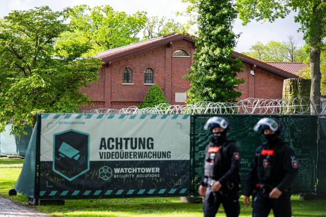 13 May 2026, Lower Saxony, Verden: Armed police are deployed in front of the converted riding facility, which is being used as a temporary courtroom for the Verden district court. In the trial against former RAF terrorist Daniela Klette for aggravated robbery, pleas from the defense are expected. Photo: Sina Schuldt/dpa