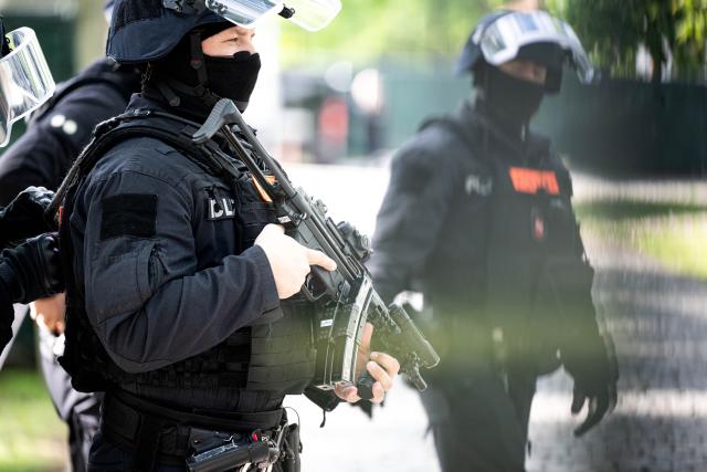 13 May 2026, Lower Saxony, Verden: Armed police are deployed in front of the converted riding facility, which is being used as a temporary courtroom for the Verden district court. In the trial against former RAF terrorist Daniela Klette for aggravated robbery, pleas from the defense are expected. Photo: Sina Schuldt/dpa