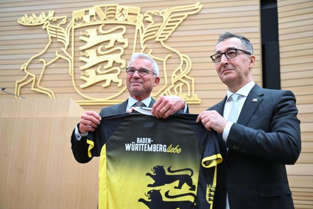 13 May 2026, Baden-Württemberg, Stuttgart: Thomas Strobl(L), President of the State Parliament of Baden-Wuerttemberg, and Cem Ozdemir, newly elected Minister President of Baden-Wuerttemberg, hold a jersey after the election. Cem Ozdemir is elected as the new Minister President of Baden-Wuerttemberg in the state parliament. Photo: Bernd Weißbrod/dpa