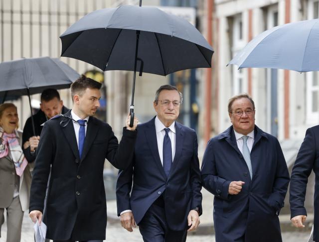 14 May 2026, North Rhine-Westphalia, Aachen: Mario Draghi, former President of the European Central Bank (ECB),  walks alongside Bundestag member Armin Laschet (R) to Aachen Cathedral. Draghi will later be awarded the Charlemagne Prize 2026. Photo: Thomas Banneyer/dpa
