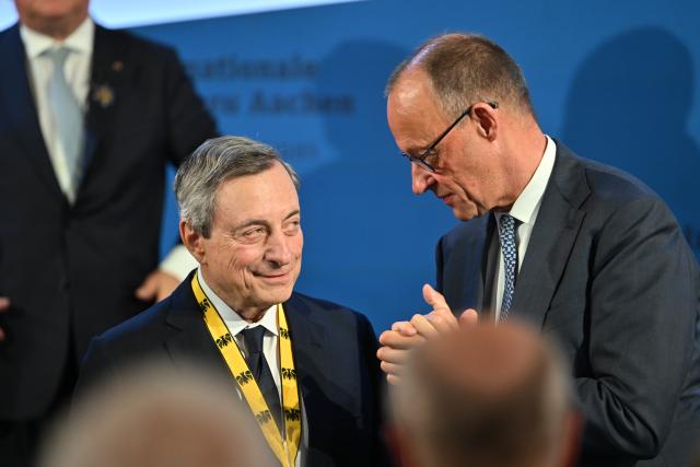 14 May 2026, North Rhine-Westphalia, Aachen: Former President of the European Central Bank (ECB) Mario Draghi stands with German Chancellor Friedrich Merz after being awarded with the Charlemagne Prize in Aachen City Hall. Photo: Henning Kaiser/dpa