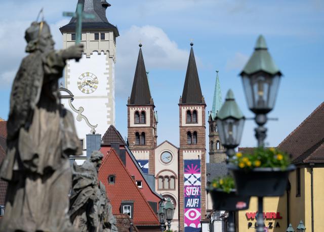 14 May 2026, Bavaria, Wuerzburg: Statues of saints stand on the Old Main Bridge during the 104th German Catholic Convention, with the towers of St. Kilian's Cathedral visible in the background. Photo: Sven Hoppe/dpa - ACHTUNG: Nur zur redaktionellen Verwendung und nur mit vollständiger Nennung des vorstehenden Credits