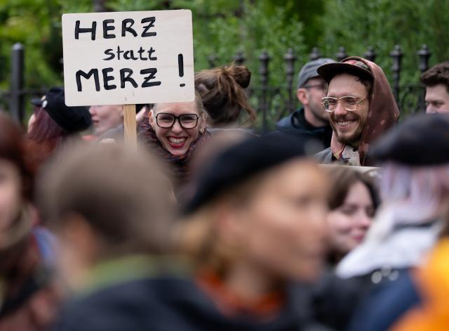 15 May 2026, Bavaria, Wuerzburg: Demonstrators protest against German Chancellor Merz's visit at the 104th German Catholic Congress and hold a sign reading "Herz statt Merz" (Heart instead of Merz). Photo: Sven Hoppe/dpa - ATTENTION: editorial use only and only if the credit mentioned above is referenced in full