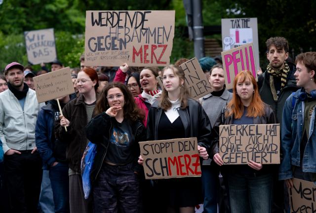15 May 2026, Bavaria, Wuerzburg: Demonstrators protest against Chancellor Merz's visit at the 104th German Catholic Congress. Photo: Sven Hoppe/dpa - ATTENTION: editorial use only and only if the credit mentioned above is referenced in full