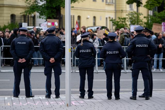 15 May 2026, Bavaria, Wuerzburg: Police officers stand in front of demonstrators protesting against Chancellor Merz's visit at the 104th German Catholic Congress. Photo: Sven Hoppe/dpa - ATTENTION: editorial use only and only if the credit mentioned above is referenced in full