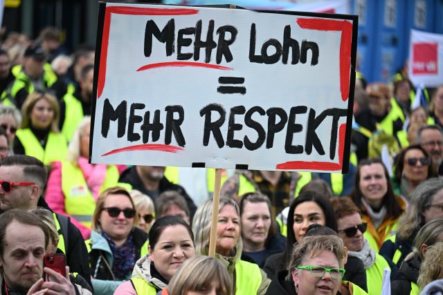15 May 2026, North Rhine-Westphalia, Dortmund: Retail workers demonstrate with a sign "More pay = more respect" in front of the soccer museum. Verdi has called for warning strikes this Friday in the ongoing wage negotiations in the retail sector. Photo: Federico Gambarini/dpa
