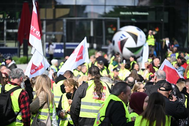 15 May 2026, North Rhine-Westphalia, Dortmund: Retail workers demonstrate with flags in front of the soccer museum. Verdi has called for warning strikes this Friday in the ongoing wage negotiations in the retail sector. Photo: Federico Gambarini/dpa