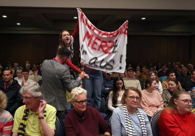 15 May 2026, Bavaria, Wuerzburg: Activists disrupt the panel discussion with Chancellor Merz at the 104th German Catholic Congress. Photo: Karl-Josef Hildenbrand/dpa - ATTENTION: For editorial use only and only with full reference to the above credit