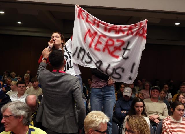 15 May 2026, Bavaria, Wuerzburg: Activists disrupt the panel discussion with Chancellor Merz at the 104th German Catholic Congress. Photo: Karl-Josef Hildenbrand/dpa - ATTENTION: For editorial use only and only with full reference to the above credit