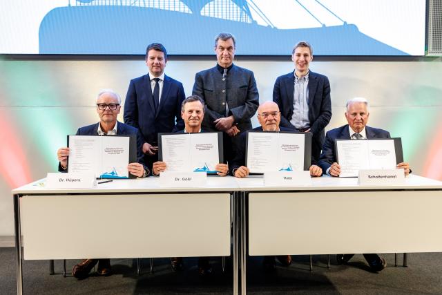 15 May 2026, Bavaria, Munich: Frank Huepers, Managing Director of the Association of Bavarian Chambers of Crafts (l-r), Manfred Goessl, Managing Director of the Association of Bavarian Chambers of Industry and Commerce, Wolfram Hatz, President of the Bavarian Business Association, and Christian Schottenhamel, spokesman for the Pro Olympia Alliance, present a memorandum from the Bavarian business community to Sandro Kirchner (back l-r), State Secretary in the Bavarian Ministry of the Interior, Markus Soeder, Party Chairman and Minister President of Bavaria, and Dominik Krause, Lord Mayor of Munich, at a media event on Munich's in-depth bid concept for the Olympic Games. Photo: Matthias Balk/dpa