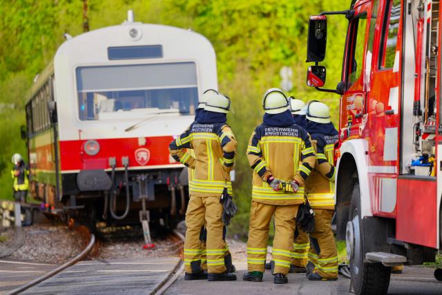 15 May 2026, Baden-Württemberg, Trochtelfingen: Firefighters stand in front of a train after an accident, where a man in the district of Reutlingen was seriously injured when the train collided with his car. Photo: Enrique Kaczor/onw-images/dpa