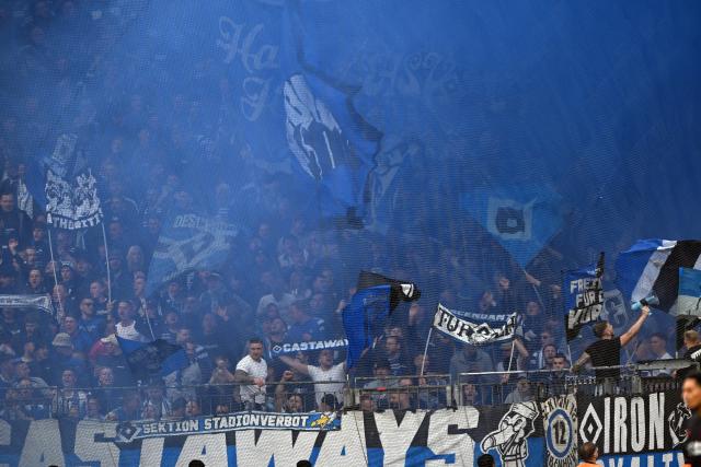 16 May 2026, North Rhine-Westphalia, Leverkusen: Hamburger SV fans set off pyrotechnics in the stands during the German Bundesliga soccer match between Bayer Leverkusen and Hamburger SV at BayArena. Photo: Federico Gambarini/dpa - WICHTIGER HINWEIS: Gemäß den Vorgaben der DFL Deutsche Fußball Liga bzw. des DFB Deutscher Fußball-Bund ist es untersagt, in dem Stadion und/oder vom Spiel angefertigte Fotoaufnahmen in Form von Sequenzbildern und/oder videoähnlichen Fotostrecken zu verwerten bzw. verwerten zu lassen.