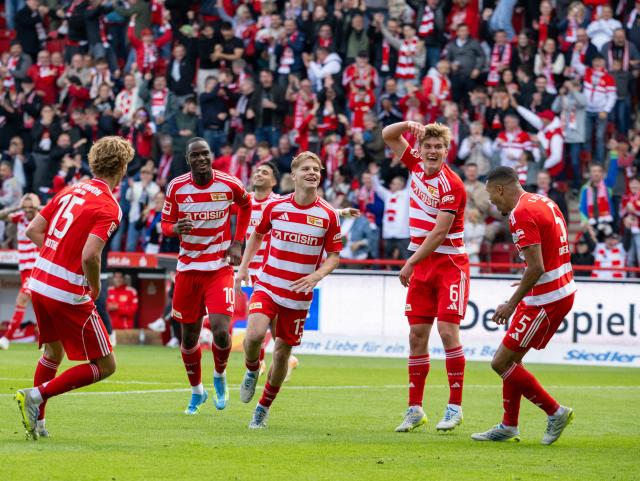 16 May 2026, Berlin: Union Berlin's Andras Schaefer (C) celebrates scoring his side's third goal with teammates during the German Bundesliga soccer match between S1. FC Union Berlin and FC Augsburg at An der Alten Foersterei. Photo: Soeren Stache/dpa - WICHTIGER HINWEIS: Gemäß den Vorgaben der DFL Deutsche Fußball Liga bzw. des DFB Deutscher Fußball-Bund ist es untersagt, in dem Stadion und/oder vom Spiel angefertigte Fotoaufnahmen in Form von Sequenzbildern und/oder videoähnlichen Fotostrecken zu verwerten bzw. verwerten zu lassen.