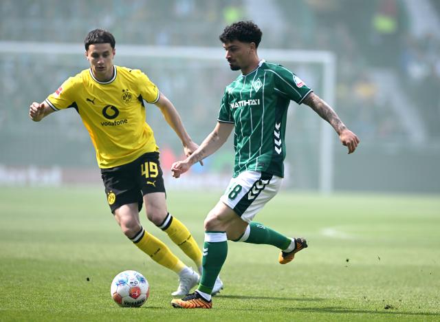 16 May 2026, Bremen: Borussia Dortmund's Luca Reggiani (L) and Werder Bremen's Cameron Puertas battle for the ball during the German Bundesliga soccer match between SV Werder Bremen and Borussia Dortmund at Weserstadion. Photo: Carmen Jaspersen/dpa - WICHTIGER HINWEIS: Gemäß den Vorgaben der DFL Deutsche Fußball Liga bzw. des DFB Deutscher Fußball-Bund ist es untersagt, in dem Stadion und/oder vom Spiel angefertigte Fotoaufnahmen in Form von Sequenzbildern und/oder videoähnlichen Fotostrecken zu verwerten bzw. verwerten zu lassen.
