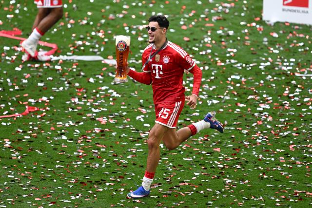 16 May 2026, Bavaria, Munich: Bayern Munich's Aleksandar Pavlovic runs across the field with a glass of beer during the championship celebration after the German Bundesliga soccer match between Bayern Munich and 1. FC Cologne at Allianz Arena. Photo: Sven Hoppe/dpa - IMPORTANT NOTICE: DFL and DFB regulations prohibit any use of photographs as image sequences and/or quasi-video.