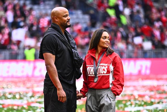 16 May 2026, Bavaria, Munich: Bayern Munich coach Vincent Kompany stands on the field with his wife Carla during the championship celebration after the German Bundesliga soccer match between Bayern Munich and 1. FC Cologne at Allianz Arena. Photo: Tom Weller/dpa - IMPORTANT NOTICE: DFL and DFB regulations prohibit any use of photographs as image sequences and/or quasi-video.