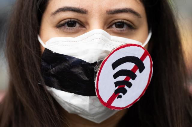 16 May 2026, Hesse, Frankfurt/Main: A woman wears a mask featuring a Wi-Fi symbol to protest internet censorship in Iran during a demonstration at Rathenauplatz in support of the Iranian opposition politician and son of the Shah, Mohammad Reza Pahlavi. Photo: Boris Roessler/dpa