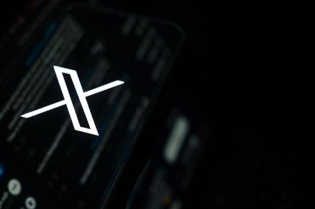 FILED - 12 May 2025, Berlin: FILE PHOTO - The logo of the short messaging service X can be seen on a smartphone resting on a keyboard. Photo: Jennifer Brückner/dpa