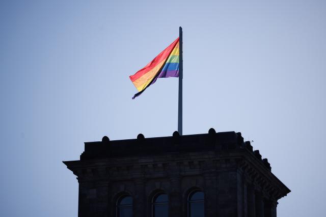 17 May 2026, Berlin: The rainbow flag is flying over the Reichstag building to mark the International Day Against Homophobia. Photo: Carsten Koall/dpa