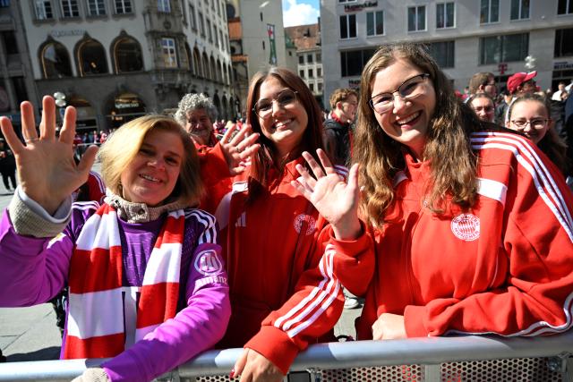 17 May 2026, Bavaria, Munich: (L-R) Bayern Munich fans Julia, Caro, and Cathy stand at Marienplatz before the arrival of FC Bayern players to celebrate the German Bundesliga championship on the balcony of City Hall. Photo: Felix Hörhager/dpa