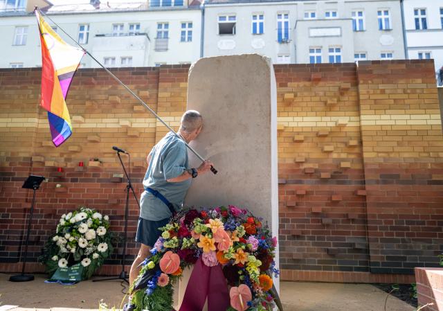 17 May 2026, Berlin: A person kisses the Kissing Stone during the dedication of the new burial and memorial site for queer people, established by Schwulenberatung Berlin at St. Matthaeus Churchyard. Photo: Fabian Sommer/dpa
