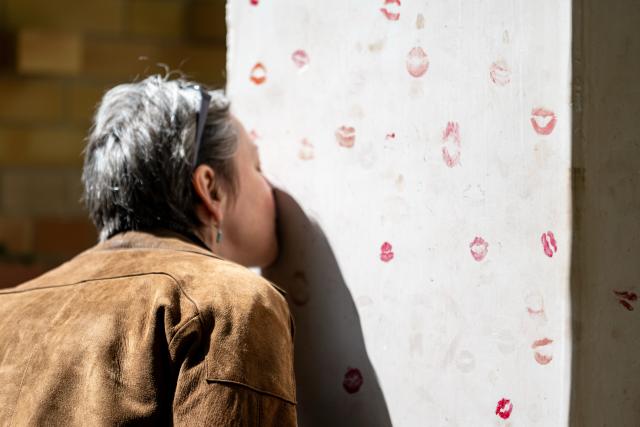 17 May 2026, Berlin: A person kisses the Kissing Stone during the dedication of the new burial and memorial site for queer people, established by Schwulenberatung Berlin at St. Matthaeus Churchyard. Photo: Fabian Sommer/dpa