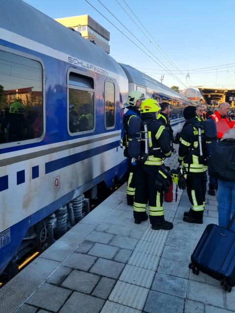 HANDOUT - 17 May 2026, Bavaria, Traunstein: Passengers and emergency personnel stand on a platform. Early Sunday morning, emergency responders in Traunstein evacuated a passenger train carrying 250 passengers. Photo: -/Bayerisches Rotes Kreuz/dpa - ACHTUNG: Nur zur redaktionellen Verwendung im Zusammenhang mit einer Berichterstattung über den Einsatz des BRK am Bahnhof Traunstein und nur mit vollständiger Nennung des vorstehenden Credits.