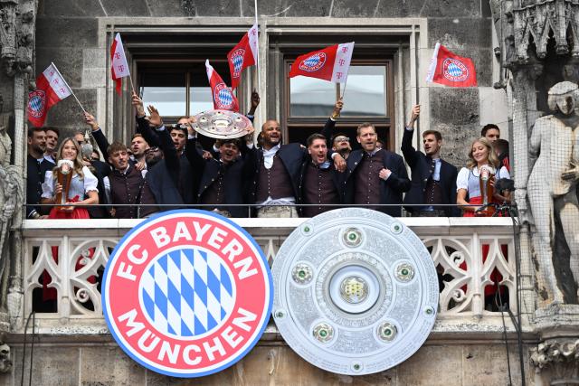 17 May 2026, Bavaria, Munich: Bayern Munich players, coaches, and staff celebrate with the trophy on the town hall balcony during the German Bundesliga championship celebrations at Marienplatz. Photo: Sven Hoppe/dpa