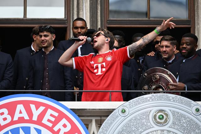 17 May 2026, Bavaria, Munich: Musician Oimara sings on the town hall balcony during Bayern Munich's celebrations of their German Bundesliga championship title at Marienplatz in Munich. Photo: Sven Hoppe/dpa