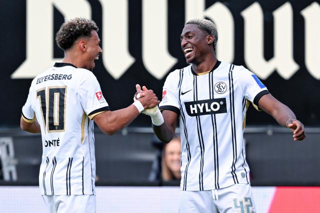 17 May 2026, Spiesen-Elversberg: Elversberg's David Mokwa (R) celebrates scoring his side's third goal with teammate Bambase Conte during the German 2nd Bundesliga soccer match between SV Elversberg and Preussen Muenster at the Ursapharm-Arena an der Kaiserlinde. Photo: Uwe Anspach/dpa - IMPORTANT NOTICE: DFL and DFB regulations prohibit any use of photographs as image sequences and/or quasi-video.