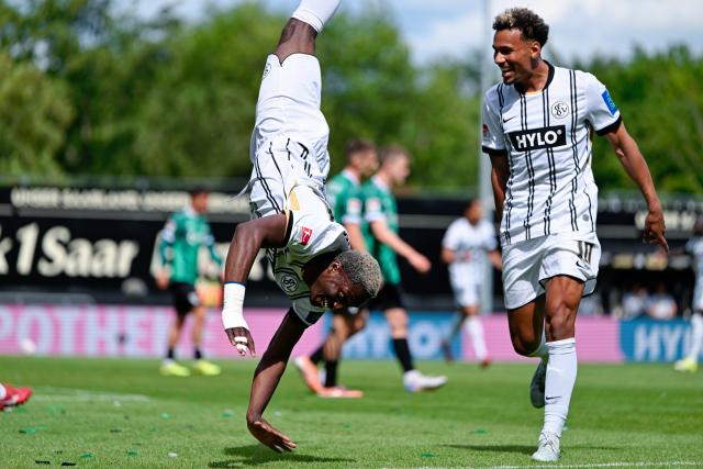 17 May 2026, Spiesen-Elversberg: Elversberg's David Mokwa (L) celebrates scoring his side's second goal with teammate Bambase Conte during the German 2nd Bundesliga soccer match between SV Elversberg and Preussen Muenster at the Ursapharm-Arena an der Kaiserlinde. Photo: Uwe Anspach/dpa - IMPORTANT NOTICE: DFL and DFB regulations prohibit any use of photographs as image sequences and/or quasi-video.