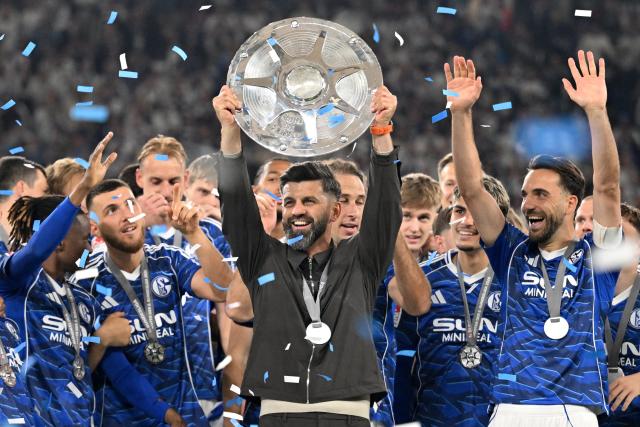 17 May 2026, North Rhine-Westphalia, Gelsenkirchen: Schalke Coach Miron Muslic holds up the 2nd Bundesliga trophy as he celebrates with team following the German 2nd Budnesliga soccer match between FC Schalke 04 and Eintracht Braunschweig at the Veltins Arena. Photo: Bernd Thissen/dpa - IMPORTANT NOTICE: DFL and DFB regulations prohibit any use of photographs as image sequences and/or quasi-video.