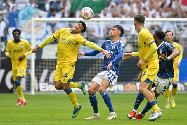 17 May 2026, North Rhine-Westphalia, Gelsenkirchen: Eintracht Braunschweig's Johan Gomez and Schalke's Dejan Ljubicic battle for the ball during the German 2nd Budnesliga soccer match between FC Schalke 04 and Eintracht Braunschweig at the Veltins Arena Photo: Bernd Thissen/dpa - IMPORTANT NOTICE: DFL and DFB regulations prohibit any use of photographs as image sequences and/or quasi-video.