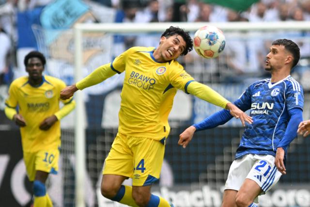 17 May 2026, North Rhine-Westphalia, Gelsenkirchen: Eintracht Braunschweig's Johan Gomez and Schalke's Dejan Ljubicic battle for the ball during the German 2nd Budnesliga soccer match between FC Schalke 04 and Eintracht Braunschweig at the Veltins Arena Photo: Bernd Thissen/dpa - IMPORTANT NOTICE: DFL and DFB regulations prohibit any use of photographs as image sequences and/or quasi-video.