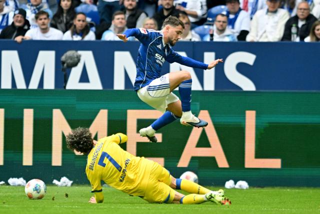 17 May 2026, North Rhine-Westphalia, Gelsenkirchen: Eintracht Braunschweig's Fabio Kaufmann and Schalke's Adil Aouchiche battle for the ball during the German 2nd Budnesliga soccer match between FC Schalke 04 and Eintracht Braunschweig at the Veltins Arena Photo: Bernd Thissen/dpa - IMPORTANT NOTICE: DFL and DFB regulations prohibit any use of photographs as image sequences and/or quasi-video.