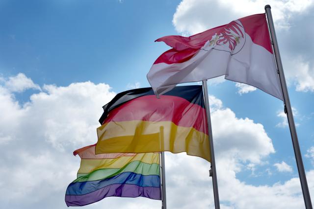 18 May 2026, Brandenburg, Potsdam: The rainbow flag flies in the wind next to the German flag and the Brandenburg flag in the courtyard of the Brandenburg State Parliament to mark the International Day against Homo-, Bi-, Inter- and Transphobia. Photo: Sven Kaeuler/dpa