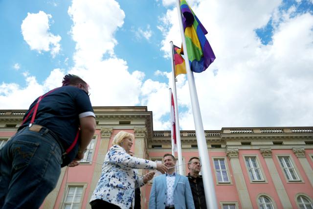 18 May 2026, Brandenburg, Potsdam: Ulrike Liedtke, President of the Brandenburg State Parliament, raises the rainbow flag in the courtyard of the Brandenburg State Parliament to mark the International Day against Homo-, Bi-, Inter- and Transphobia. Photo: Sven Kaeuler/dpa