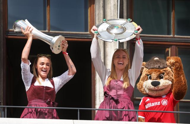 18 May 2026, Munich: Bayern Munich's Giorgia Stanway (L) holds up the DFB Cup while Glodis Viggosdottir holds the Bundesliga championship trophy as Bayern Munich Women celebrate their German Bundesliga and DFB Cup titles on the balcony of Munich City Hall. Photo: Karl-Josef Hildenbrand/dpa