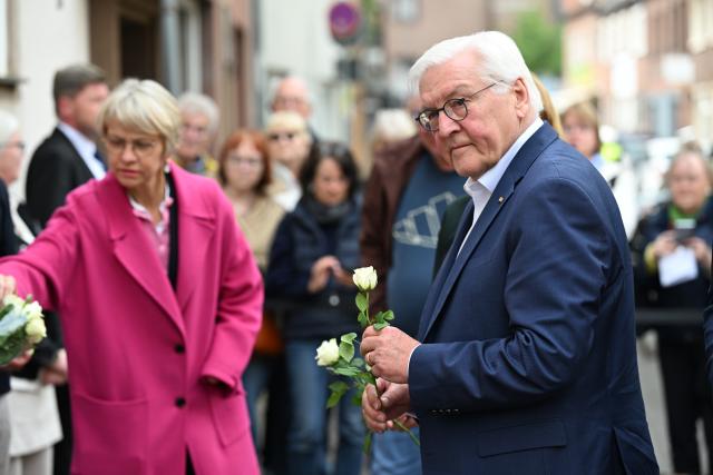 18 May 2026, Dorsten: German President Frank-Walter Steinmeier, lays white roses at the Stolpersteine in memory of the victims of National Socialism. Steinmeier's visit to Dorsten marks the start of the nationwide Day of the Basic Law. Photo: Federico Gambarini/dpa
