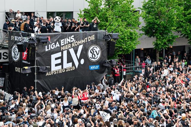 18 May 2026, Saarland, Spiesen-Elversberg: Elversberg team ride on their open-tub bus during a parade celebrating their promotion to the Bundesliga. Photo: Uwe Anspach/dpa - IMPORTANT NOTE: In accordance with the regulations of the DFL German Football League and the DFB German Football Association, it is prohibited to utilize or have utilized photographs taken in the stadium and/or of the match in the form of sequential images and/or video-like photo series.