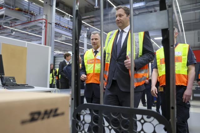 12 May 2026, Schkeuditz: German Minister of Finance Lars Klingbeil inspects parcels being checked by customs before the annual customs press conference at the DHL hub in Leipzig. Photo: Jan Woitas/dpa