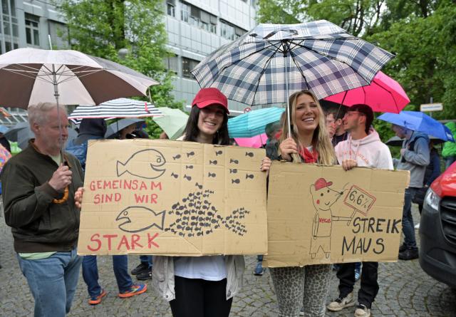 20 May 2026, Bavaria, Munich: Deutsche Telekom employees demonstrate in front of the Telekom Marsplatz site during a warning strike. The trade union Verdi is calling for nationwide work stoppages in the run-up to the fourth round of negotiations in the Deutsche Telekom collective bargaining round. Photo: Malin Wunderlich/dpa