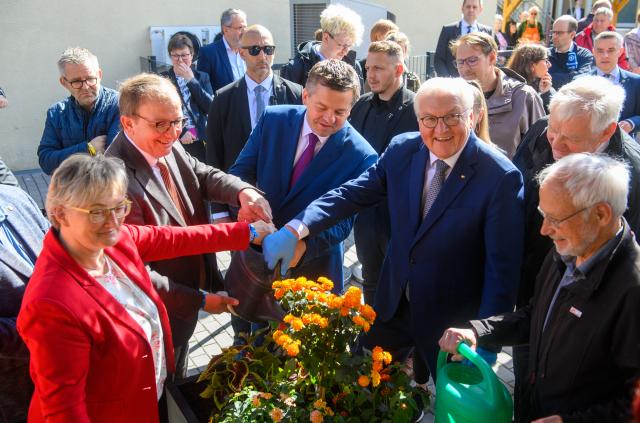20 May 2026, Saxony-Anhalt, Bernburg: (L-R) Silvia Ristow, Mayor of Bernburg, Markus Bauer, District Administrator of Salzlandkreis, Sven Schulze, Minister President of Saxony-Anhalt, and German President Frank-Walter Steinmeier water a flower pot at the social center. Steinmeier visited various activities in Bernburg as part of the first Germany-wide Day of Honor. Photo: Klaus-Dietmar Gabbert/dpa