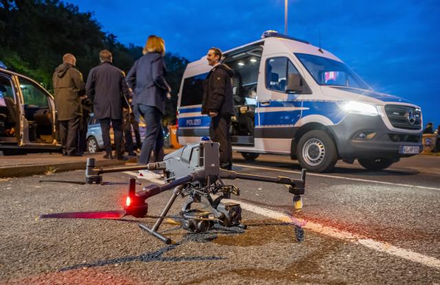 20 May 2026, Hesse, Wiesbaden: A police drone monitors a large-scale vehicle checkpoint at the Medenbach Ost motorway service station on the A3 near Wiesbaden. More than 600 officers across Hesse took part in a coordinated day of action targeting social and organised crime, forcing the complete closure of the northbound A3 toward Cologne as vehicles were filtered through the service area. Photo: Andreas Arnold/dpa