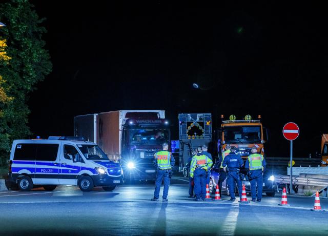 20 May 2026, Hesse, Wiesbaden: Police officers stand guard during a large-scale vehicle checkpoint at the Medenbach Ost motorway service station on the A3 near Wiesbaden. More than 600 officers across Hesse took part in a coordinated day of action targeting social and organised crime, forcing the complete closure of the northbound A3 toward Cologne as vehicles were filtered through the service area. Photo: Andreas Arnold/dpa