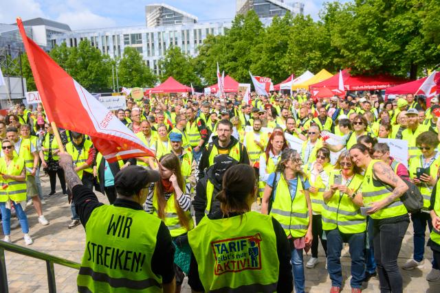 21 May 2026, Saxony-Anhalt, Magdeburg: Striking workers stand in front of a stage during a central rally hosted by the Food, Beverages and Catering Union (NGG) on Cathedral Square in Erfurt. Employees from various regional food production companies gathered to participate in the coordinated industrial action. Photo: Klaus-Dietmar Gabbert/dpa