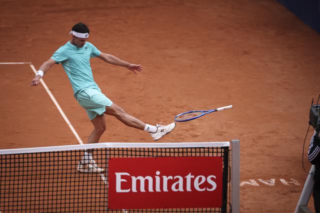 21 May 2026, Hamburg: German tennis player Daniel Altmaier stomps on his racket during his Men's Singles Quarterfinal tennis match against American Tommy Paul, sending the racket flying into the crowd. Photo: Christian Charisius/dpa