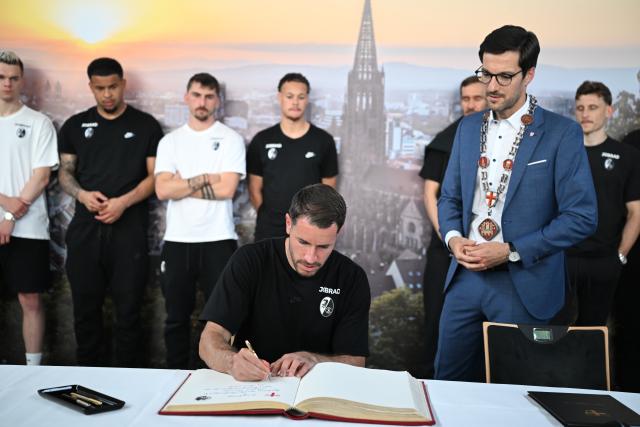 21 May 2026, Baden-Wuerttemberg, Freiburg: Freiburg's Christian Guenter signs the guest book as the Bundesliga club's team is welcomed back to Freiburg after losing the Europa League final. Aston Villa lifted their first major European trophy since 1982 by beating Germany's Freiburg 3-0 on Wednesday to win the Europa League. Photo: Bernd Weißbrod/dpa